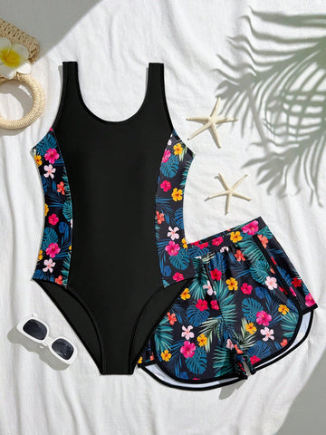 Tween girls 2-piece swimsuit set in black with full floral and plant print, featuring a sleeveless scoop-neck swim top and matching shorts-style bottoms.