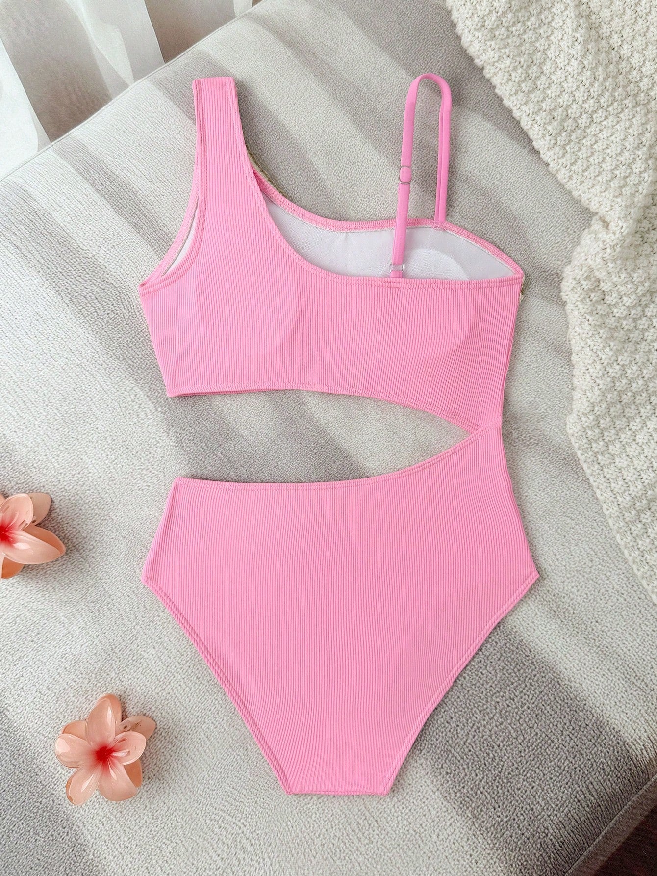 Girls black one-piece swimsuit with asymmetrical neckline, cutout waist detail, colorblock design, and medium-stretch swimsuit fabric for beach and pool wear.