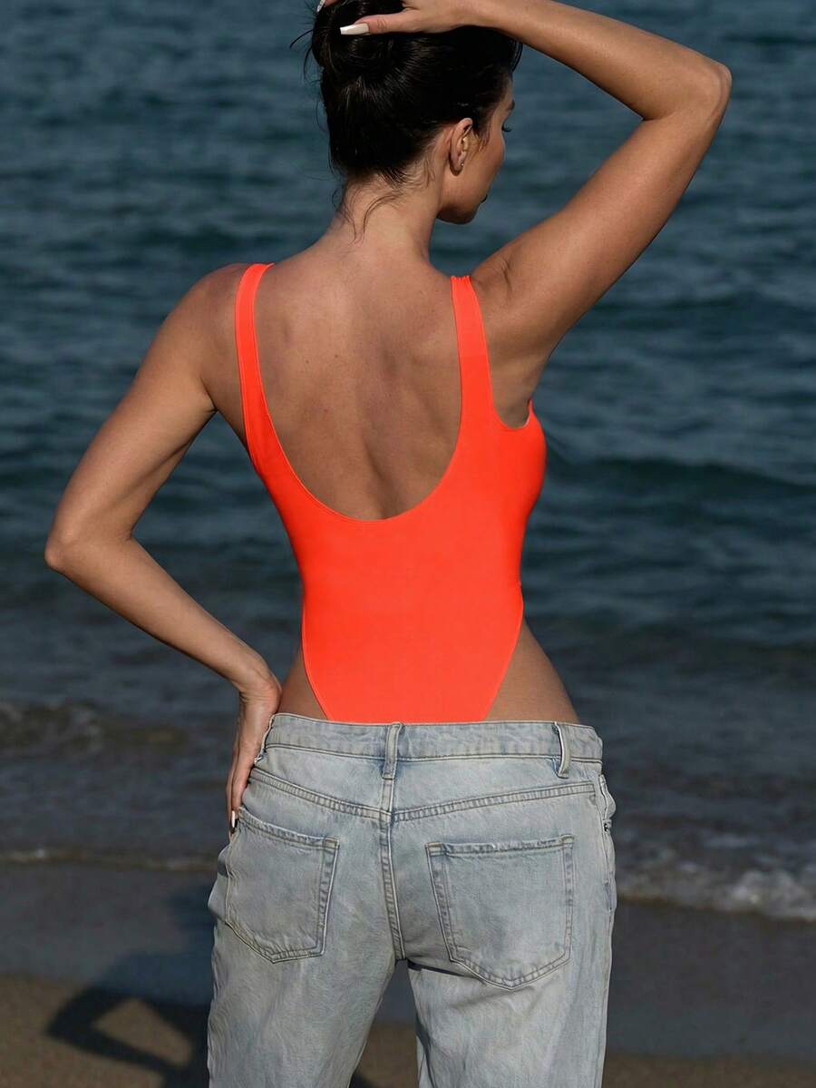 Women's solid color one-piece swimsuit featuring a backless scoop neck design and high cut fit