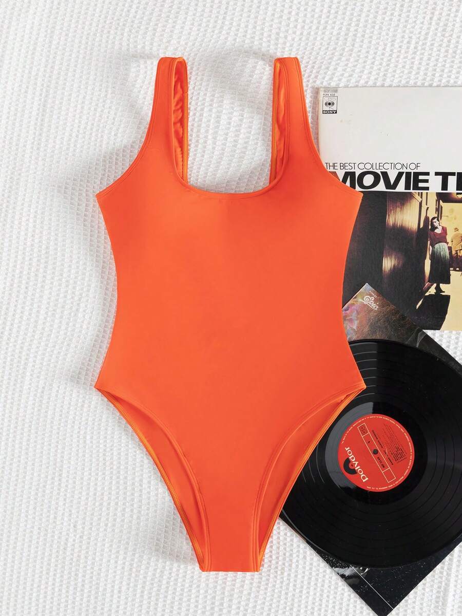Women's solid color one-piece swimsuit featuring a backless scoop neck design and high cut fit