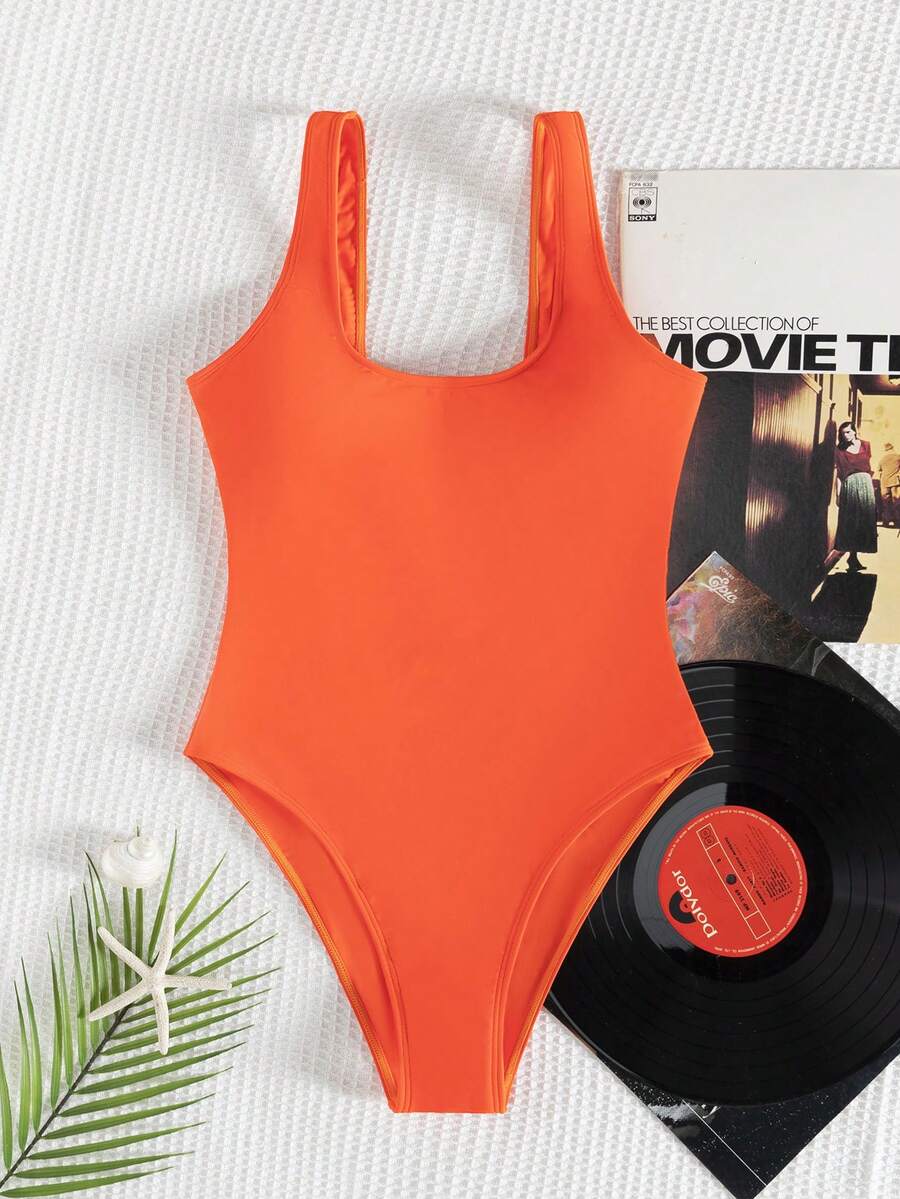 Women's solid color one-piece swimsuit featuring a backless scoop neck design and high cut fit