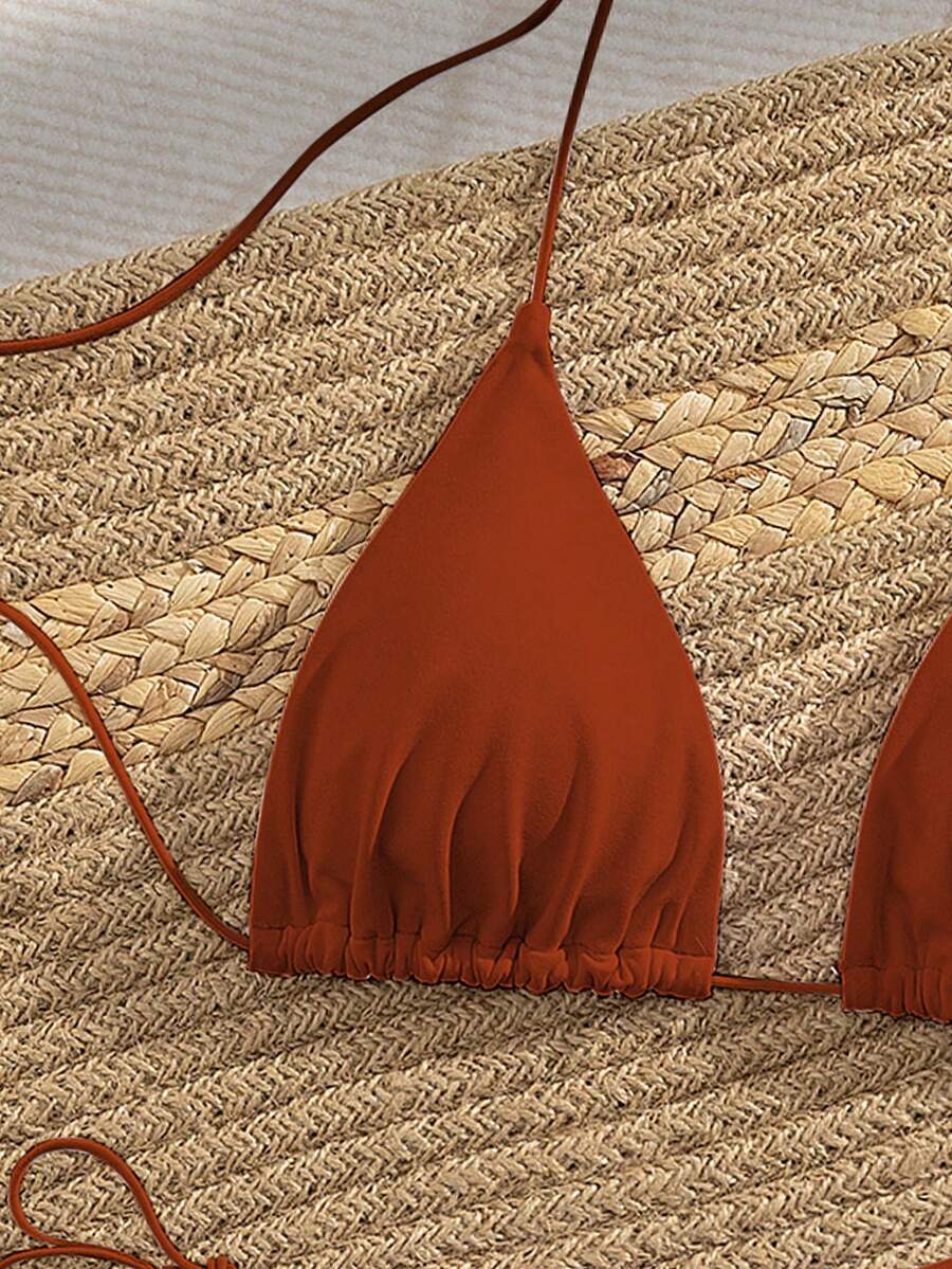 Women's 2-piece bikini set featuring a backless halter triangle top and tie-side ultra low waist bottoms.