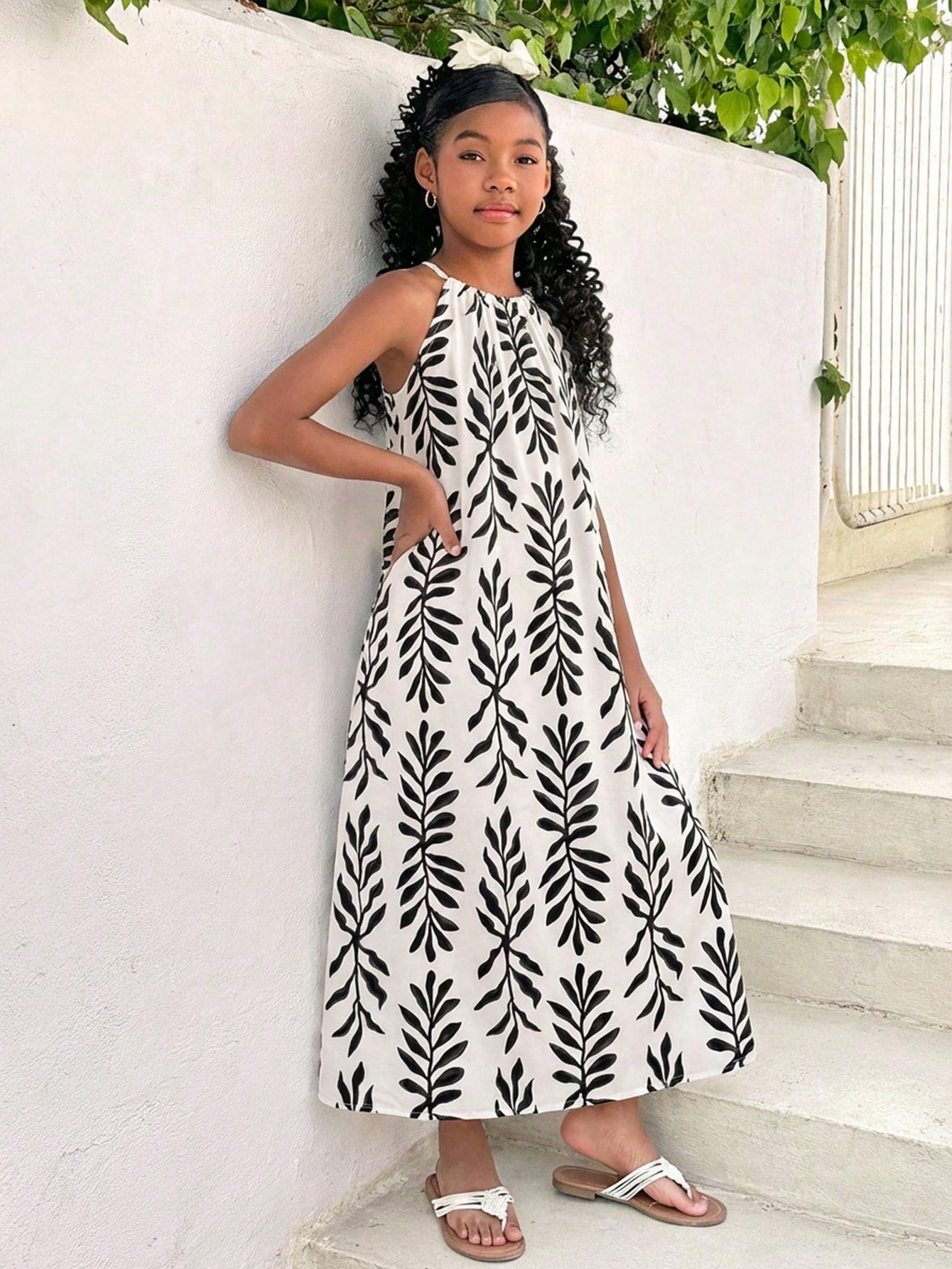 Tween girls green floral print cami dress with halter neckline, sleeveless cut, zipper detail, flared hem, and long vacation style silhouette.