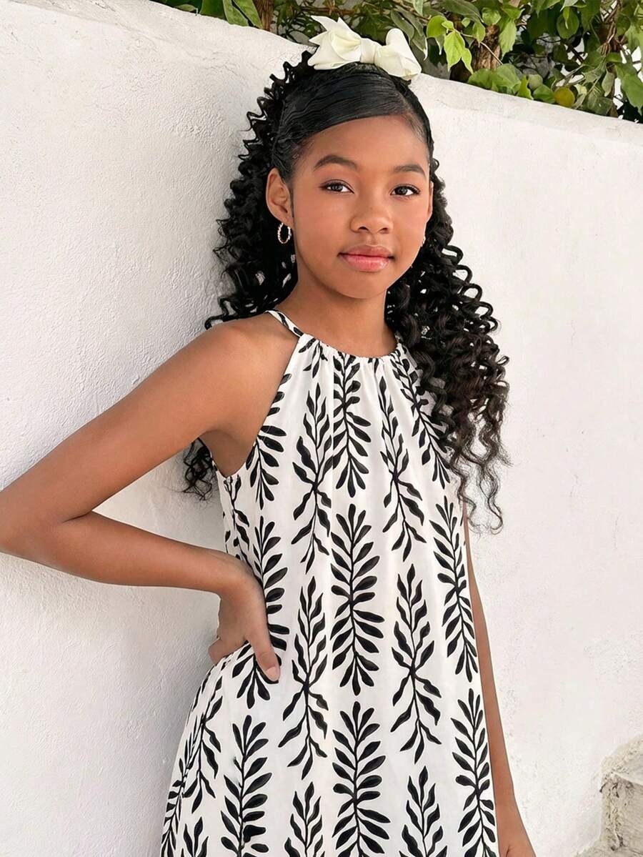 Tween girls green floral print cami dress with halter neckline, sleeveless cut, zipper detail, flared hem, and long vacation style silhouette.