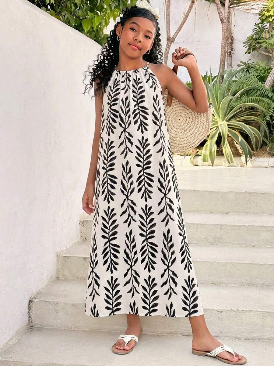 Tween girls green floral print cami dress with halter neckline, sleeveless cut, zipper detail, flared hem, and long vacation style silhouette.