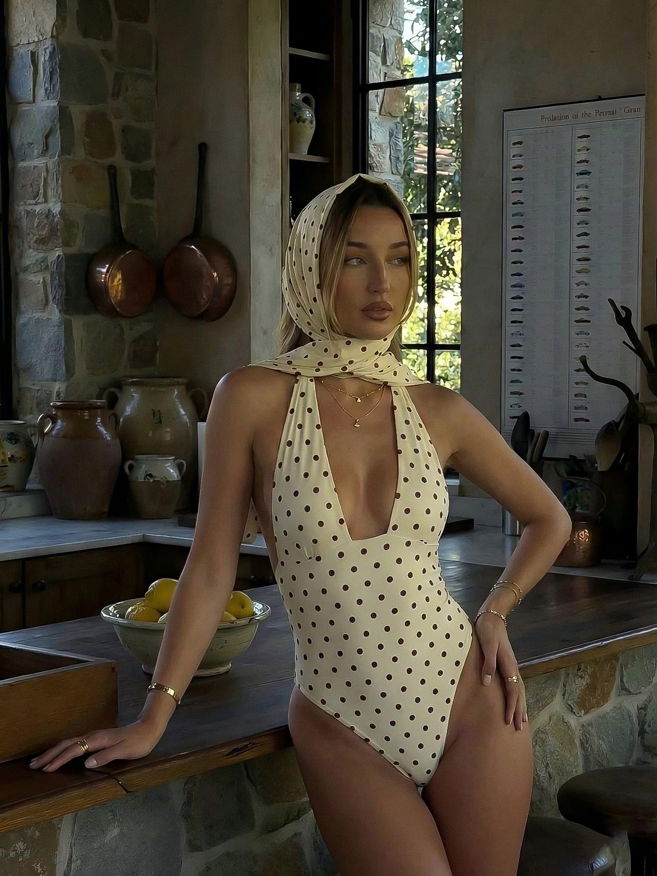 Women's apricot polka dot two-piece swimsuit featuring an asymmetrical halter backless top with knot tie detail and high-waisted bottoms.