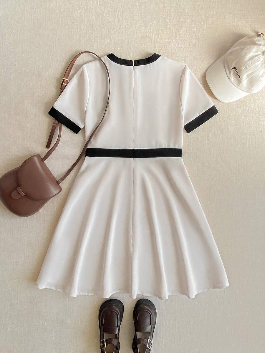 Nova Glow tween girls black and white houndstooth print short sleeve A-line dress with decorative buttons and crew neckline.