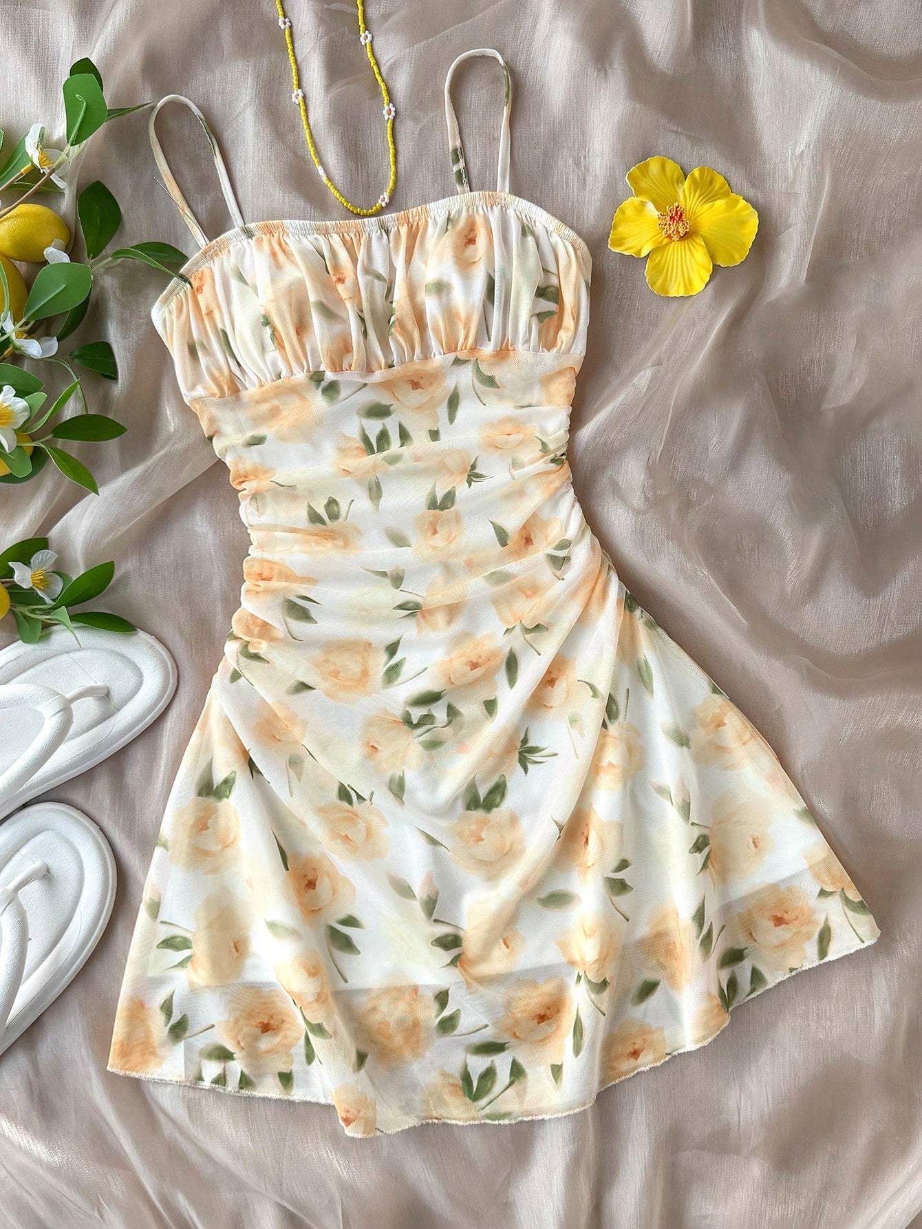 Tween girl yellow mini sundress with large pink floral hibiscus print, spaghetti straps, high waist, flared hem, and sleeveless cami style for summer beach wear