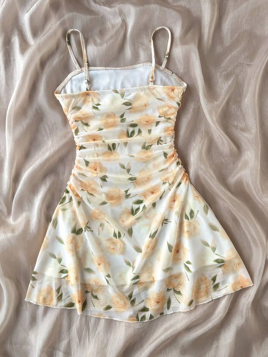 Tween girl yellow mini sundress with large pink floral hibiscus print, spaghetti straps, high waist, flared hem, and sleeveless cami style for summer beach wear