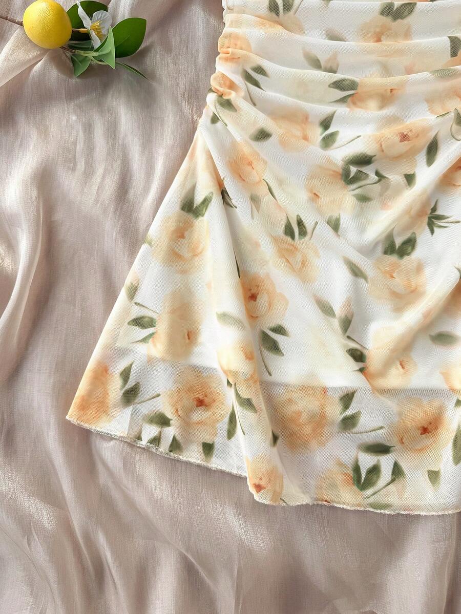 Tween girl yellow mini sundress with large pink floral hibiscus print, spaghetti straps, high waist, flared hem, and sleeveless cami style for summer beach wear
