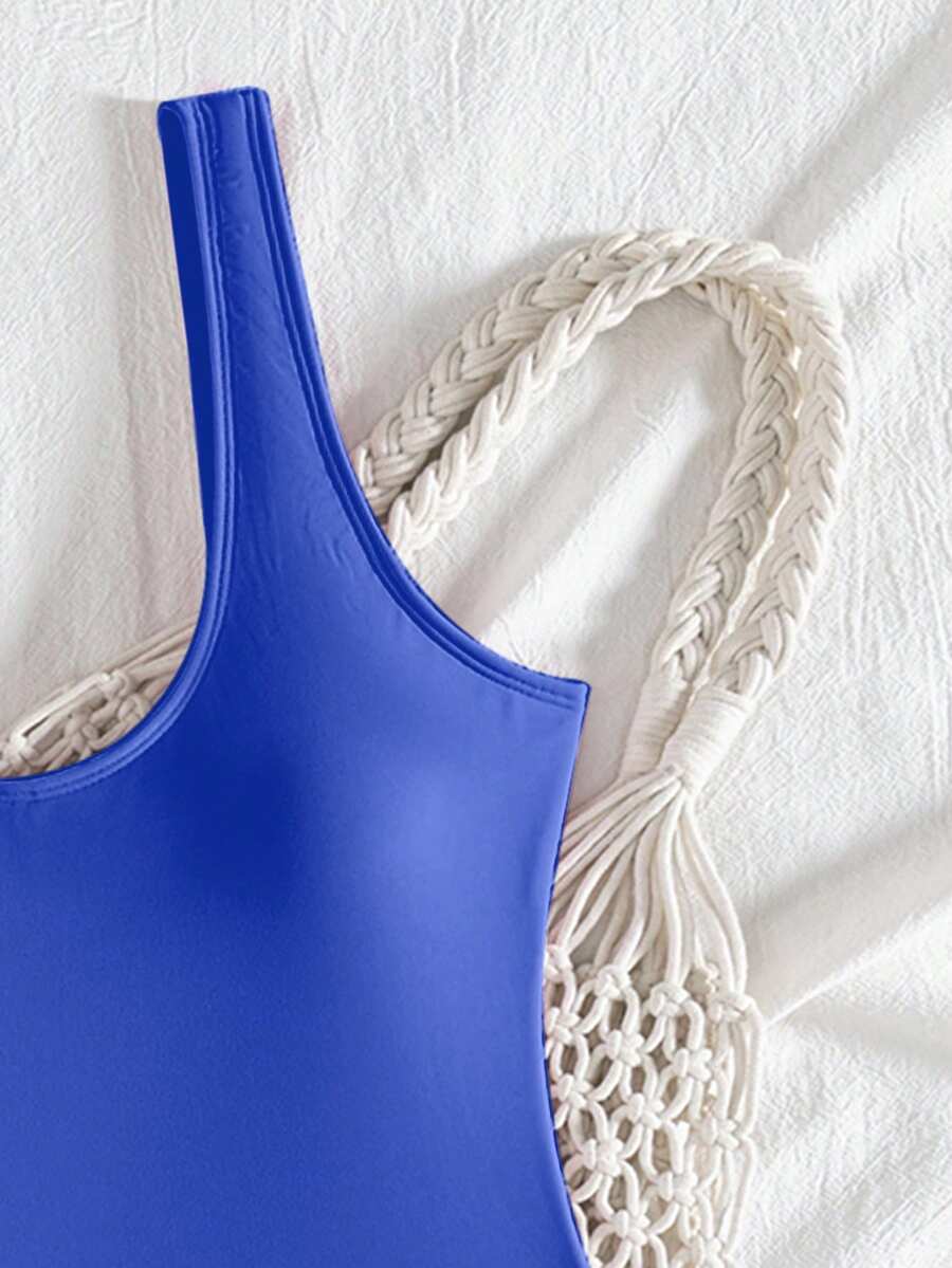 Women's solid color one-piece swimsuit featuring a backless scoop neck design and high cut fit