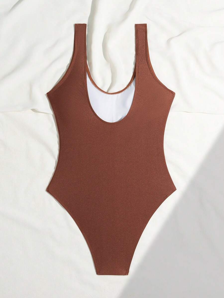 Women's solid color one-piece swimsuit featuring a backless scoop neck design and high cut fit