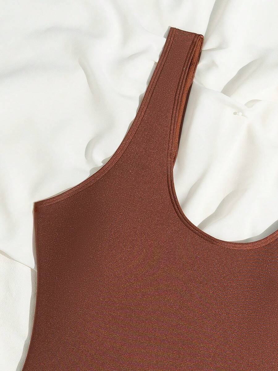 Women's solid color one-piece swimsuit featuring a backless scoop neck design and high cut fit