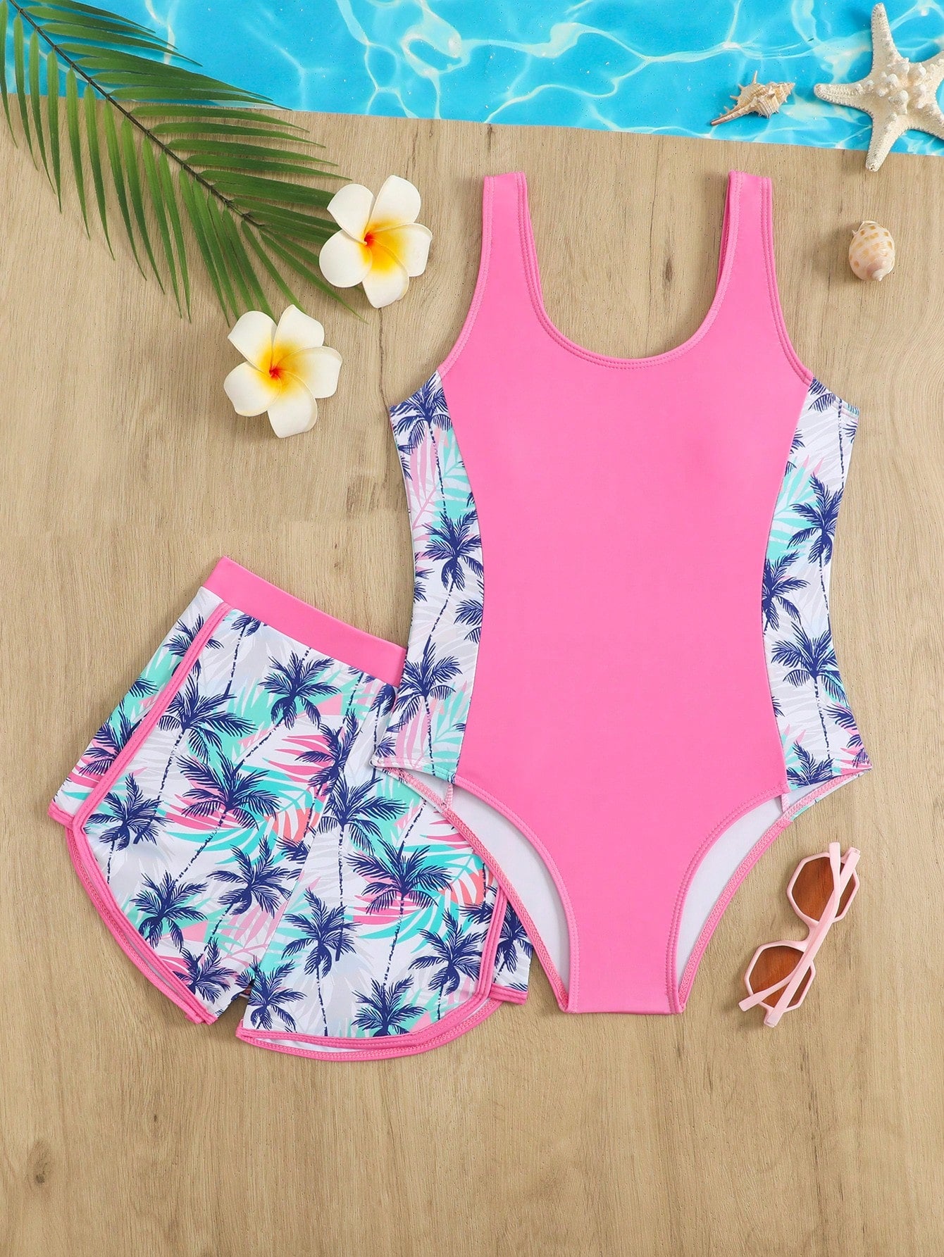 Tween girls 2-piece swimsuit set in black with full floral and plant print, featuring a sleeveless scoop-neck swim top and matching shorts-style bottoms.