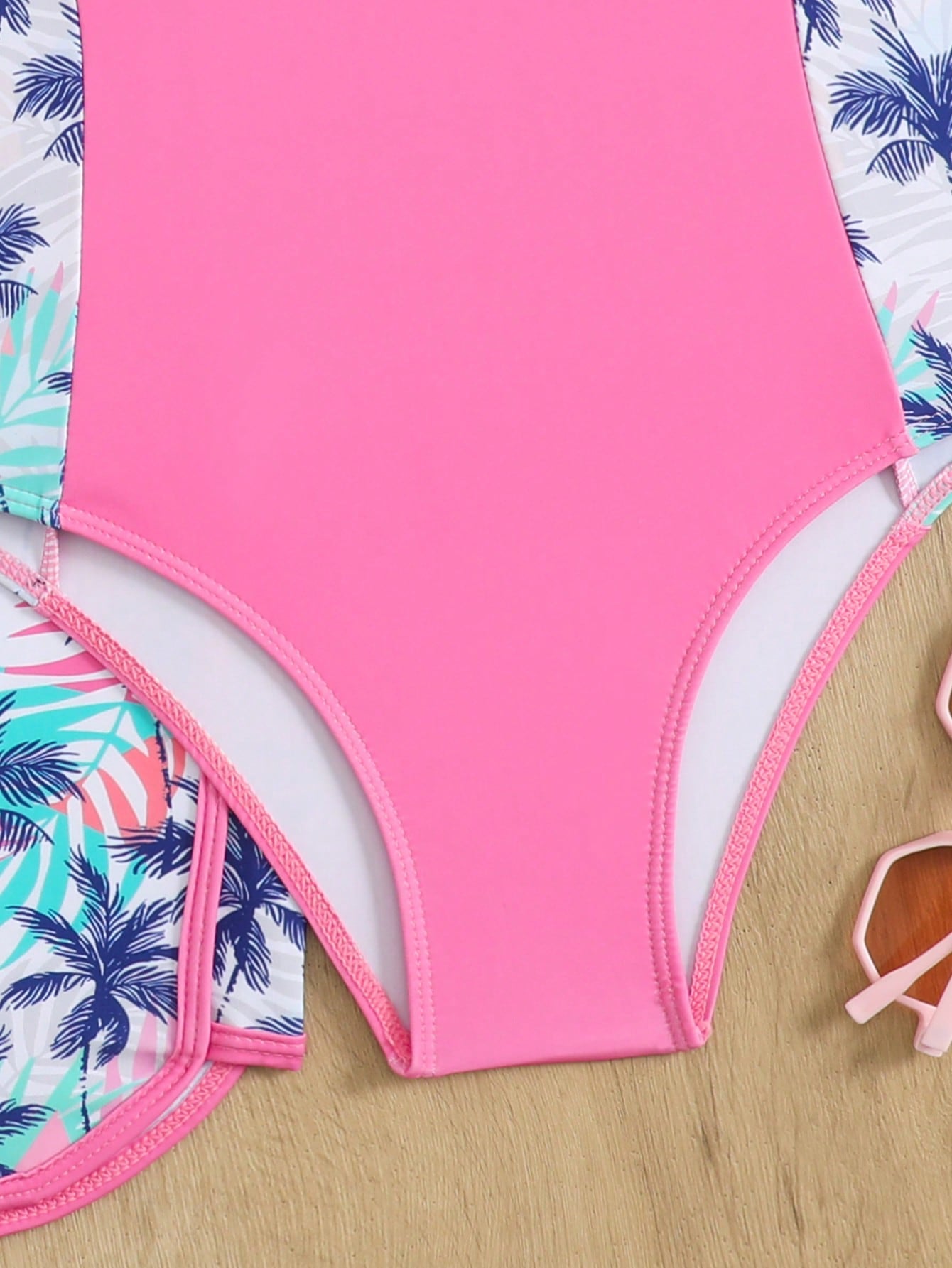 Tween girls 2-piece swimsuit set in black with full floral and plant print, featuring a sleeveless scoop-neck swim top and matching shorts-style bottoms.