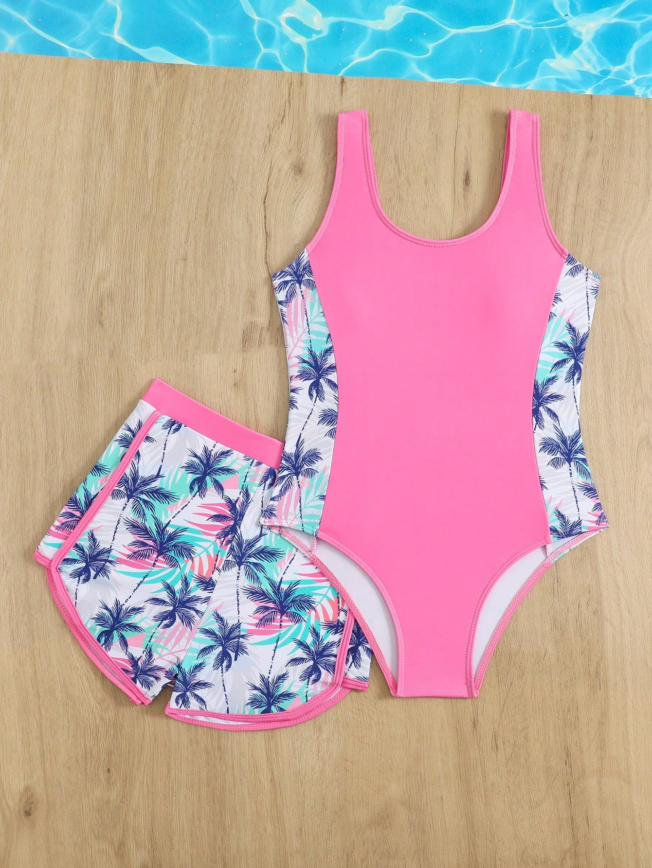 Tween girls 2-piece swimsuit set in black with full floral and plant print, featuring a sleeveless scoop-neck swim top and matching shorts-style bottoms.
