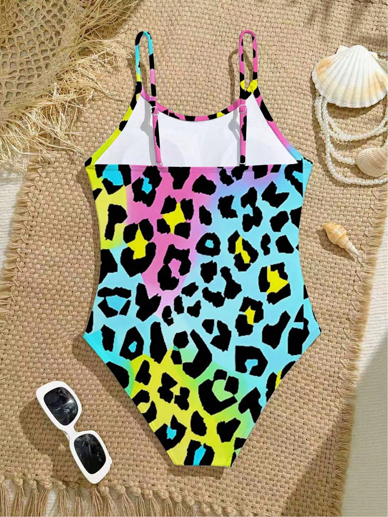 Tween girls one-piece swimsuit with a floral plant print, spaghetti straps, and a mid-waist fit in black.