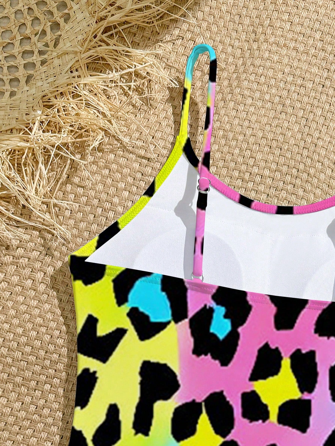 Tween girls one-piece swimsuit with a floral plant print, spaghetti straps, and a mid-waist fit in black.