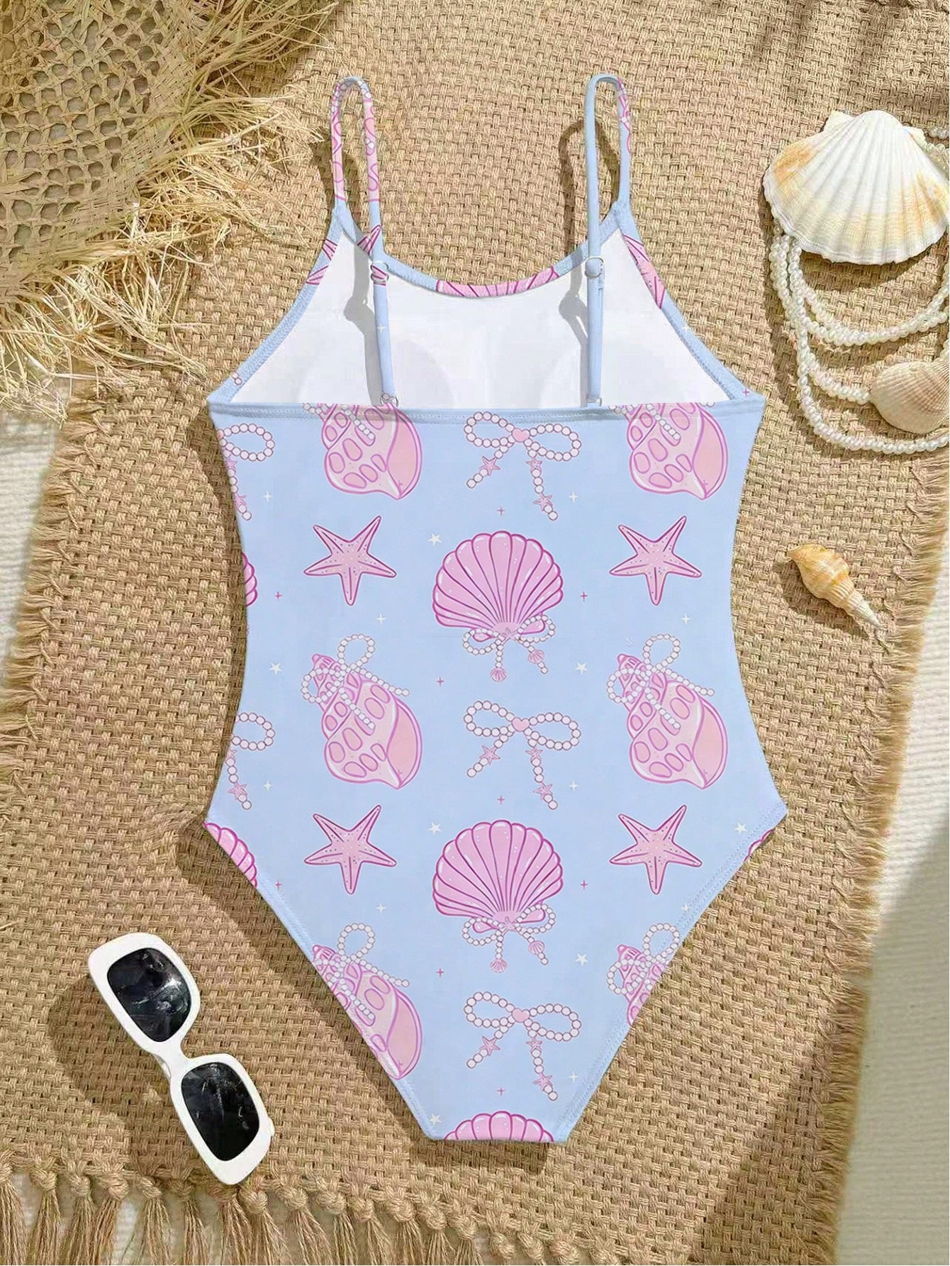 Tween girls one-piece swimsuit with a floral plant print, spaghetti straps, and a mid-waist fit in black.