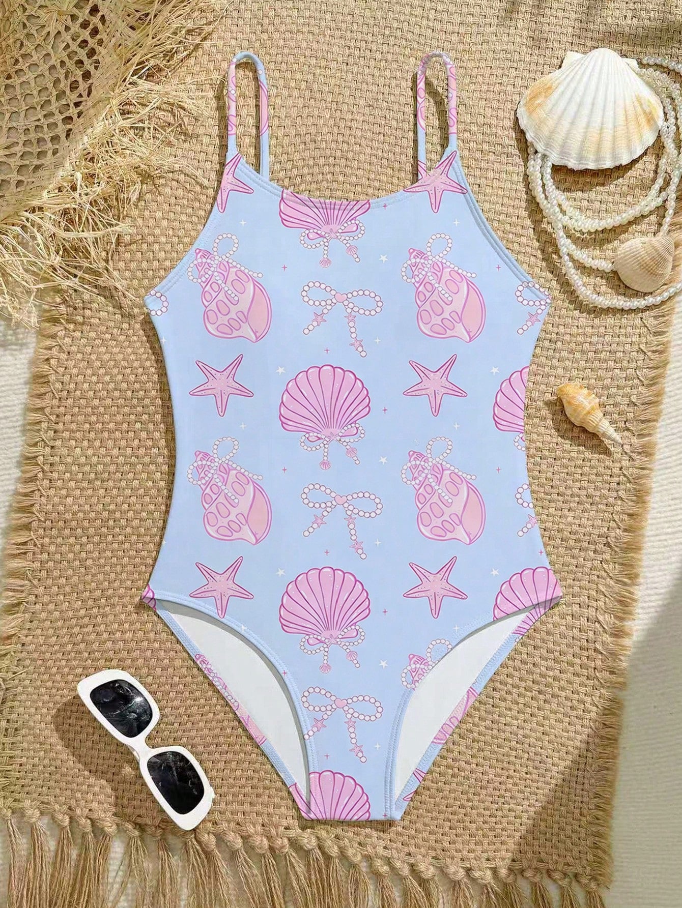 Tween girls one-piece swimsuit with a floral plant print, spaghetti straps, and a mid-waist fit in black.