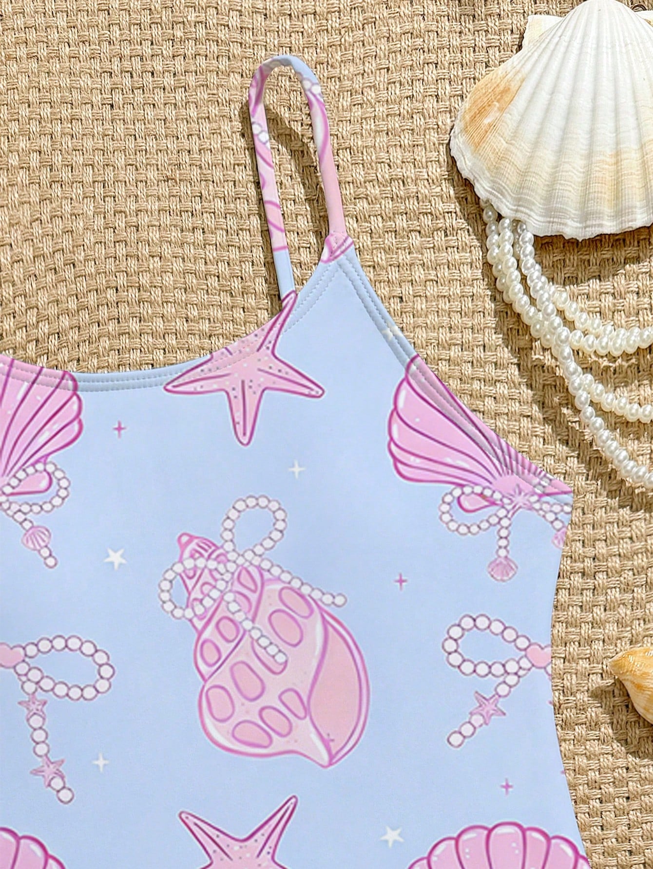 Tween girls one-piece swimsuit with a floral plant print, spaghetti straps, and a mid-waist fit in black.