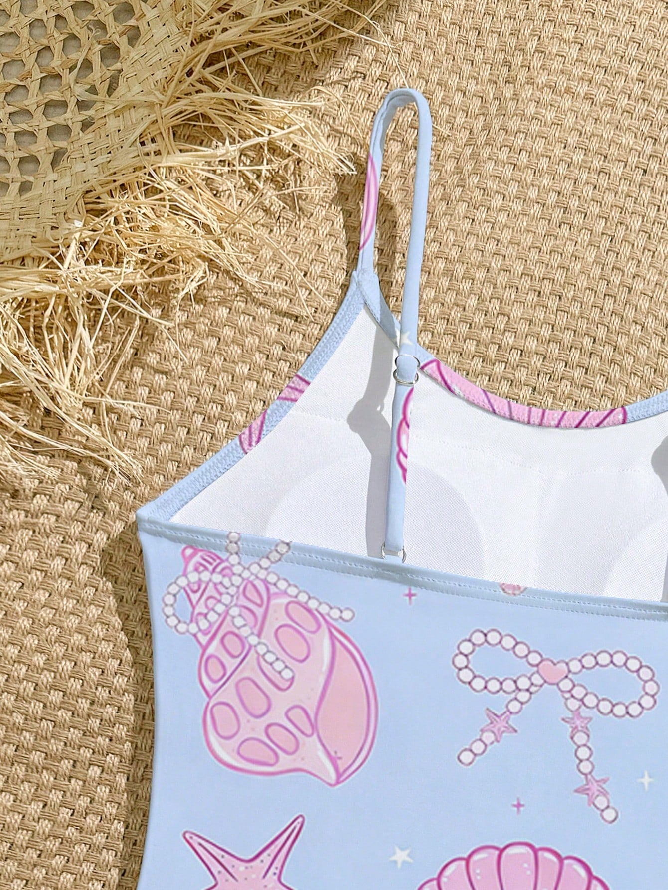Tween girls one-piece swimsuit with a floral plant print, spaghetti straps, and a mid-waist fit in black.