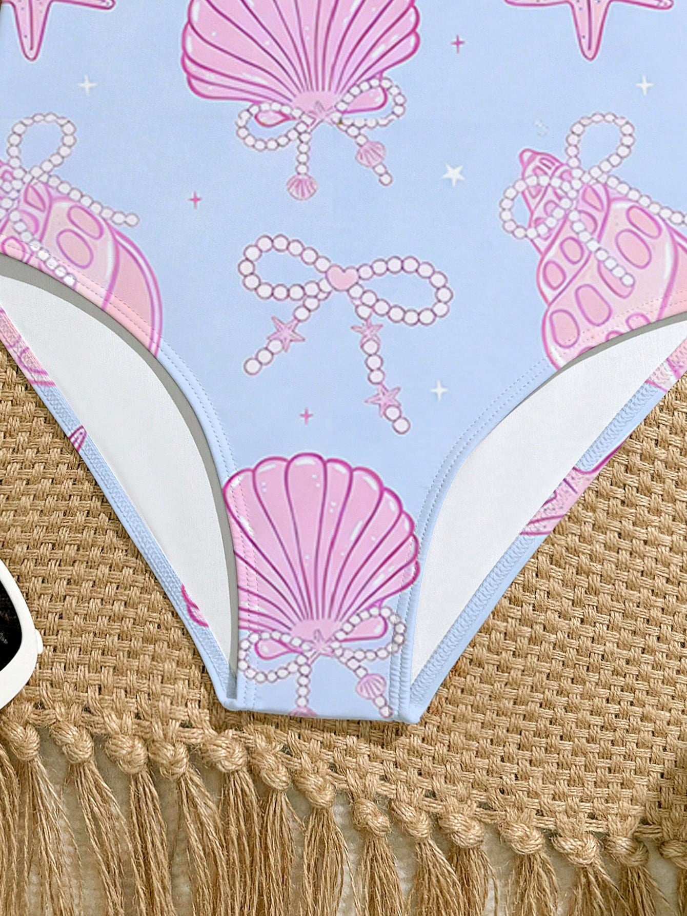 Tween girls one-piece swimsuit with a floral plant print, spaghetti straps, and a mid-waist fit in black.