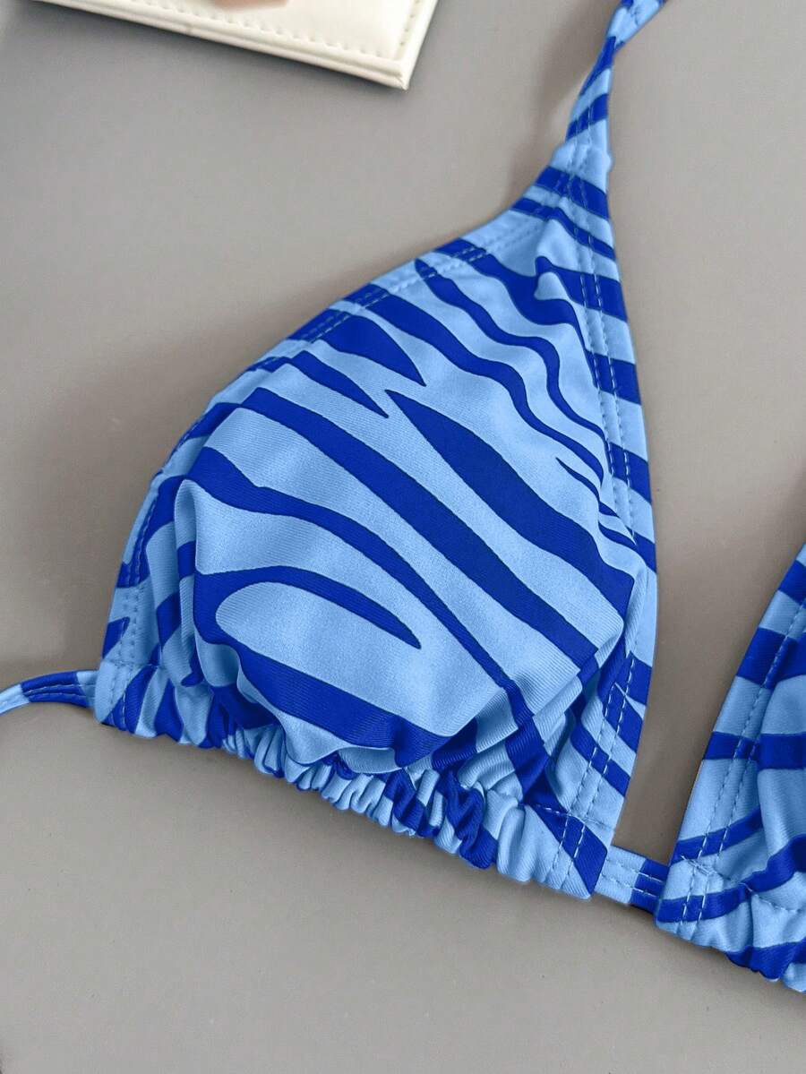 Women's black and white zebra print two-piece bikini set featuring a high waist tie-side bottom and a backless halter top with removable padding.