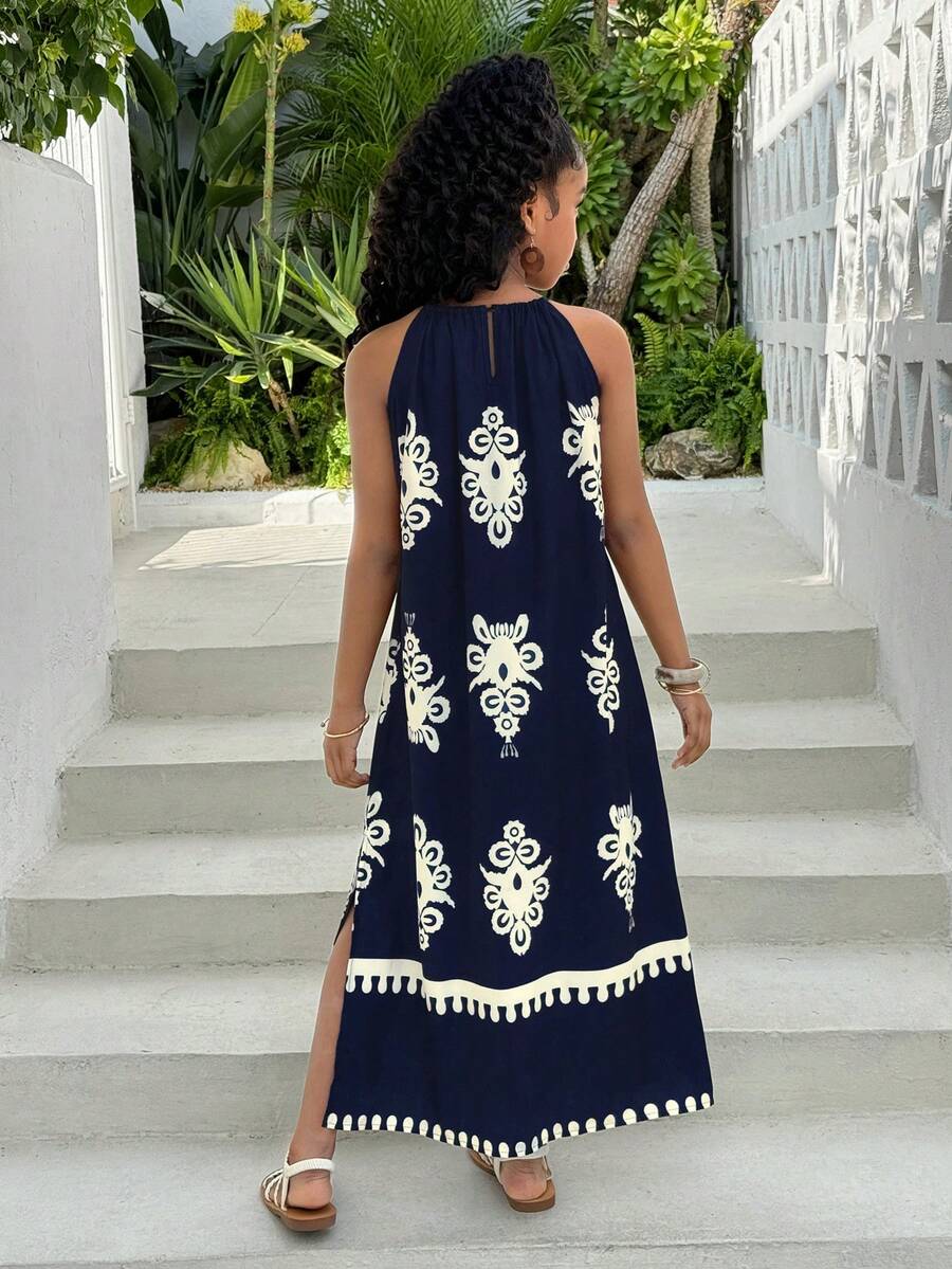 Tween girls green floral print cami dress with halter neckline, sleeveless cut, zipper detail, flared hem, and long vacation style silhouette.