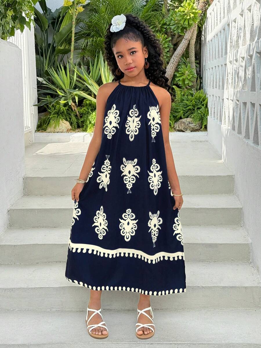 Tween girls green floral print cami dress with halter neckline, sleeveless cut, zipper detail, flared hem, and long vacation style silhouette.