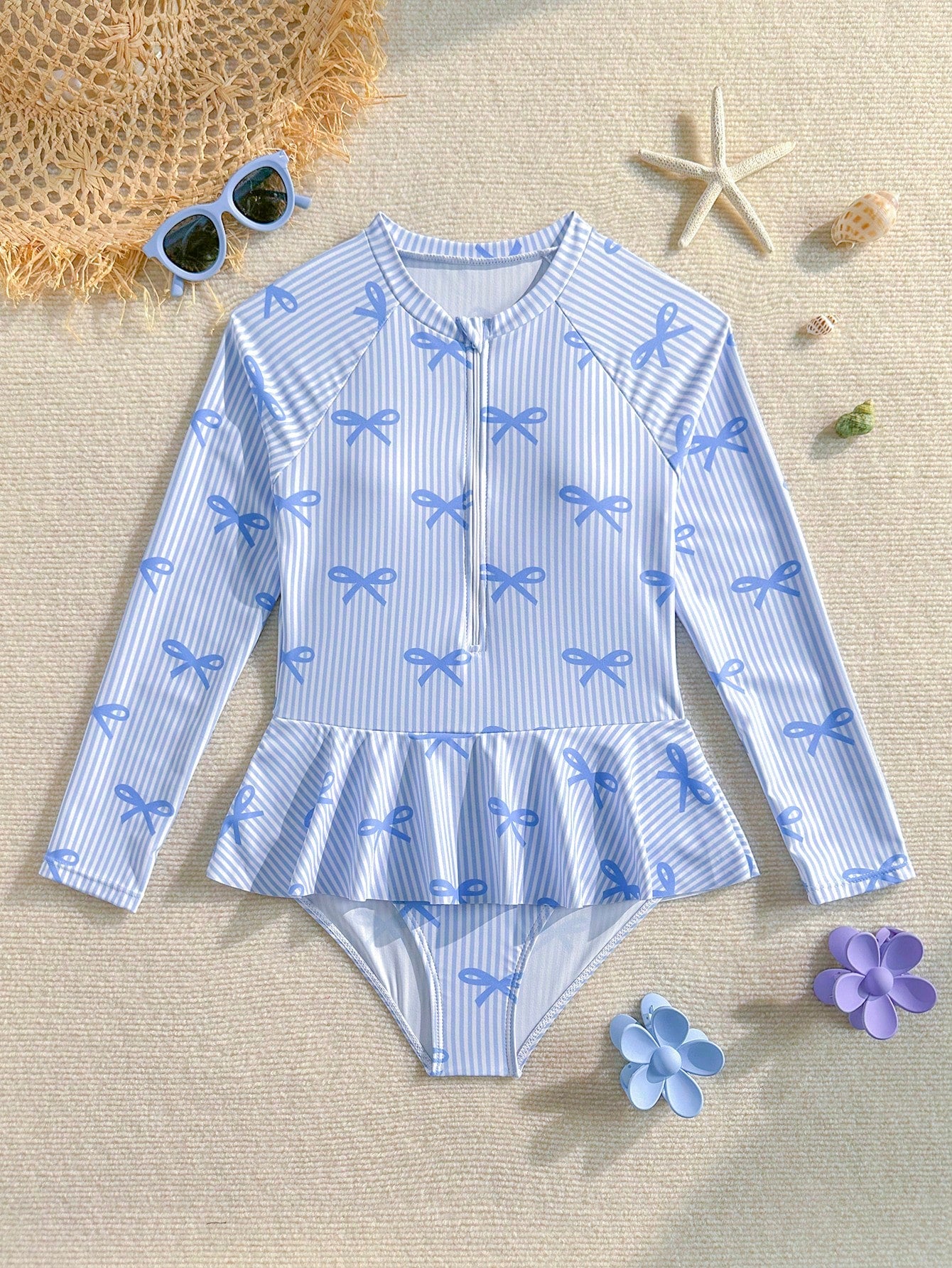Purple tween girls one-piece swimsuit with graphic striped print, ruffle detail, round neck, and zipper closure for swimming and vacation wear