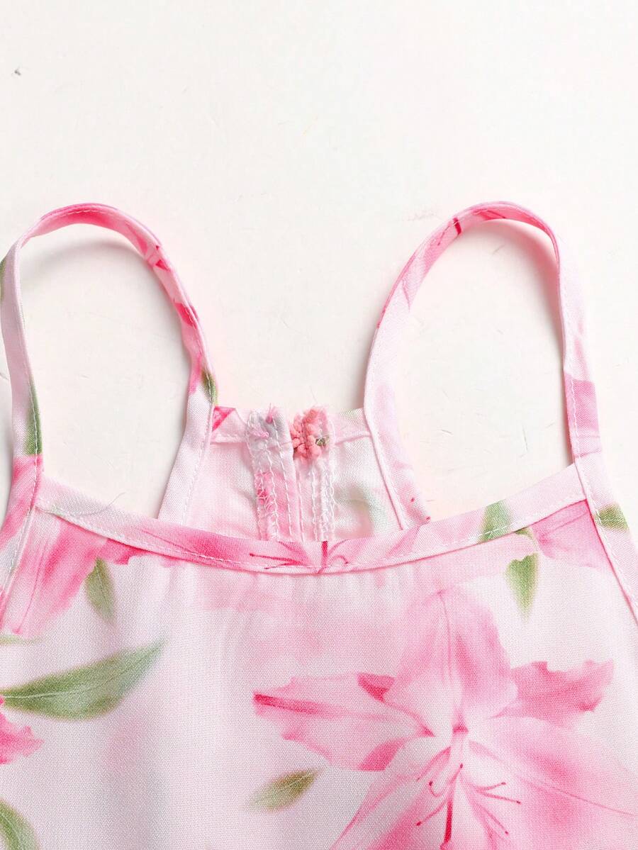 Pink floral print asymmetrical cami dress for tween girls featuring a high waist, sleeveless design, halter neckline, and back zipper.