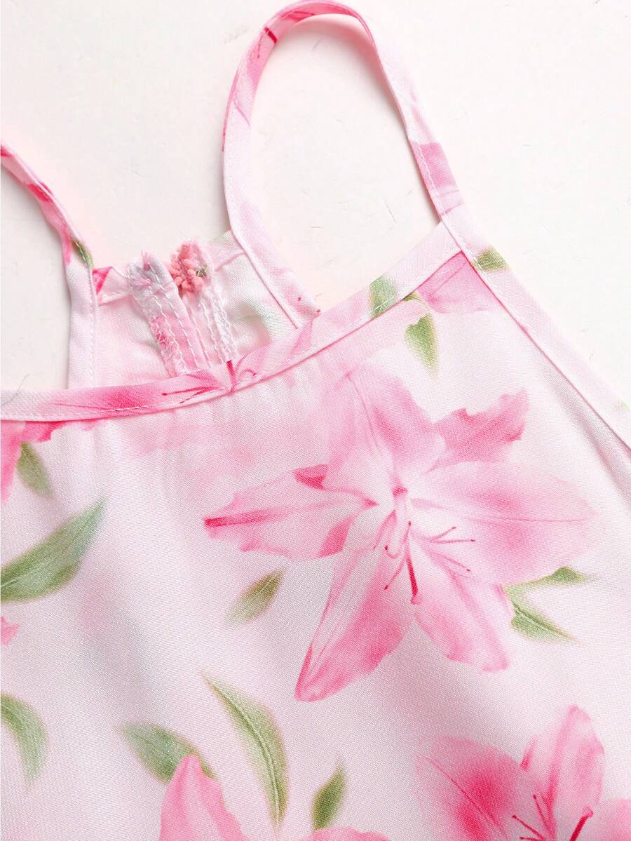 Pink floral print asymmetrical cami dress for tween girls featuring a high waist, sleeveless design, halter neckline, and back zipper.