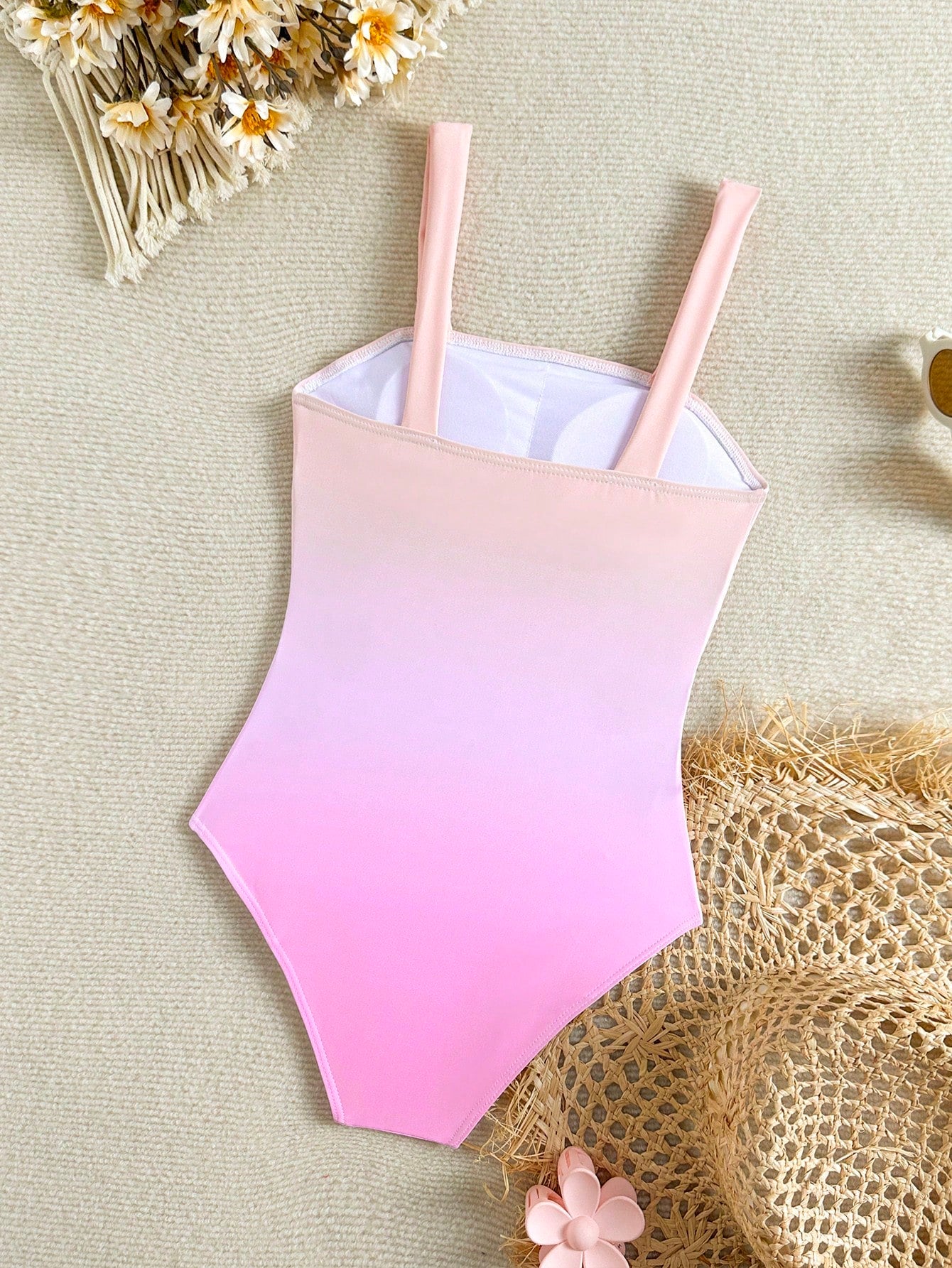 Tween girls one-piece swimsuit with a floral plant print, spaghetti straps, and a mid-waist fit in black.