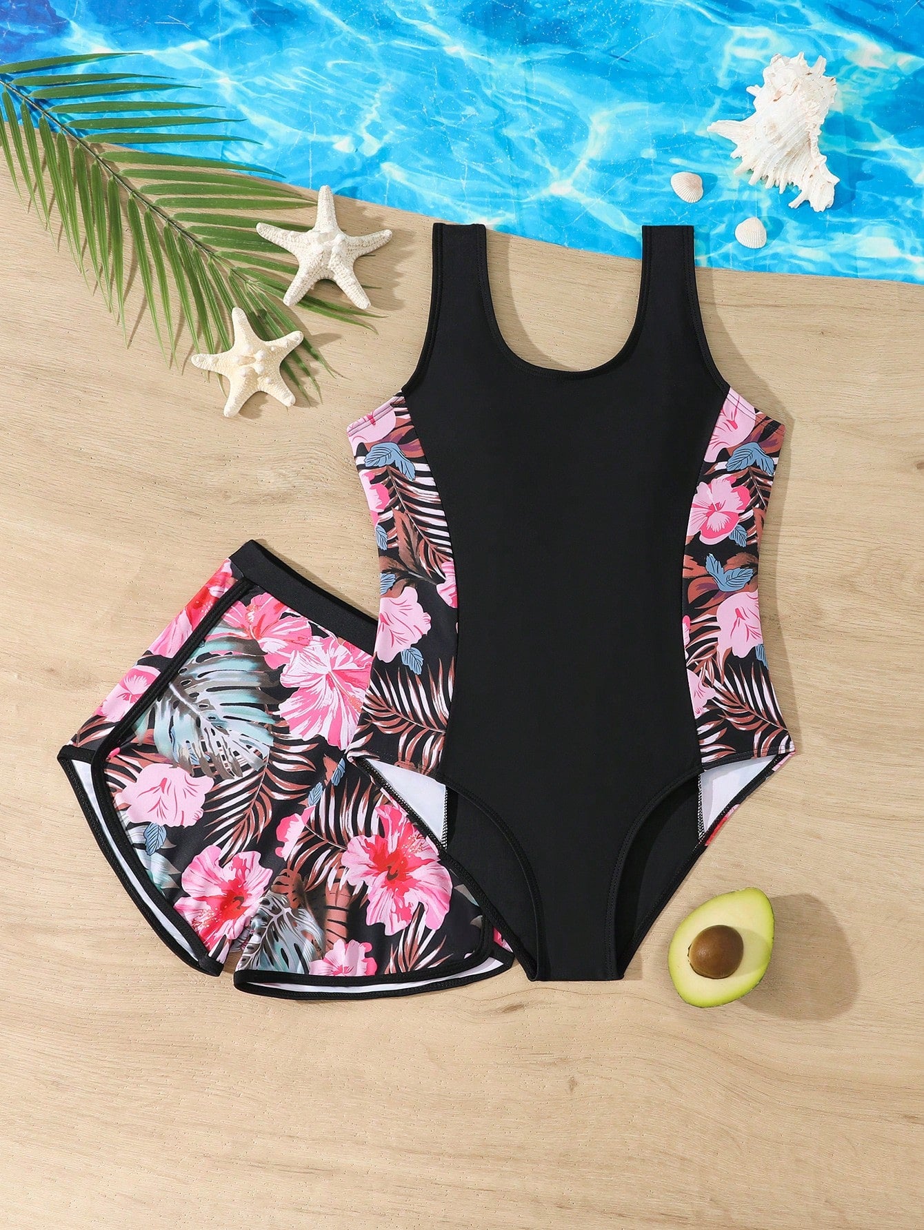 Tween girls 2-piece swimsuit set in black with full floral and plant print, featuring a sleeveless scoop-neck swim top and matching shorts-style bottoms.