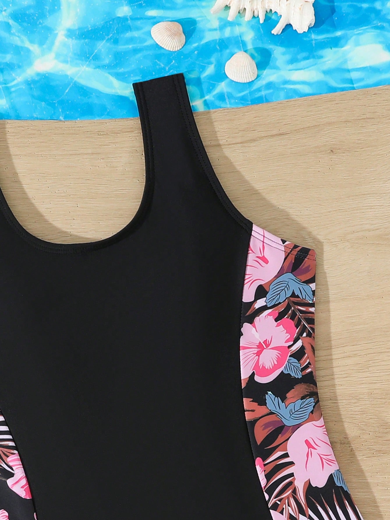 Tween girls 2-piece swimsuit set in black with full floral and plant print, featuring a sleeveless scoop-neck swim top and matching shorts-style bottoms.