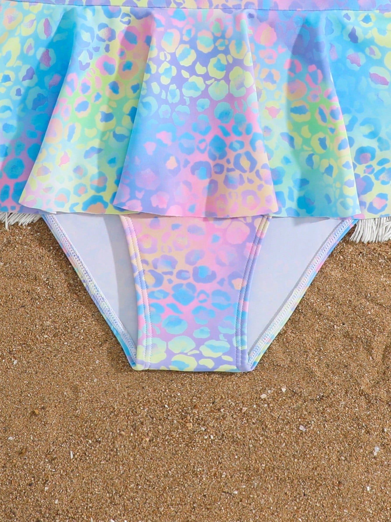 Purple tween girls one-piece swimsuit with graphic striped print, ruffle detail, round neck, and zipper closure for swimming and vacation wear