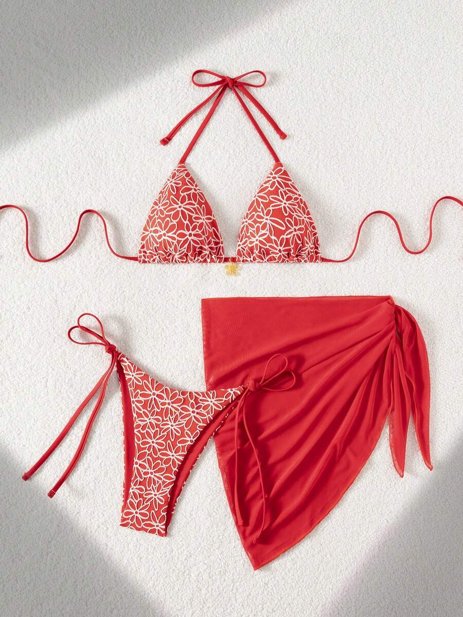 Women's 3-piece blue tropical shell print bikini set featuring a halter bralette top, low-waist tie-side bottom, and a matching sheer mesh cover-up skirt.