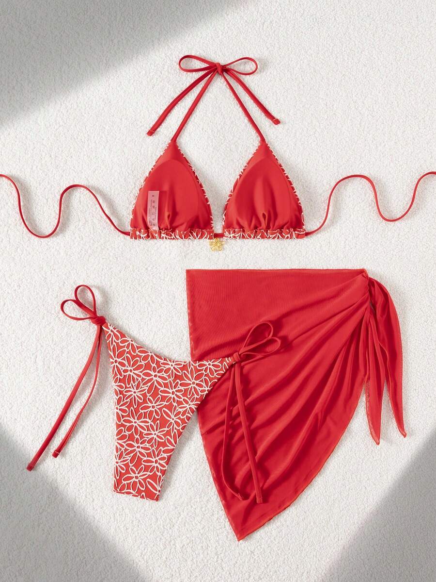 Women's 3-piece blue tropical shell print bikini set featuring a halter bralette top, low-waist tie-side bottom, and a matching sheer mesh cover-up skirt.