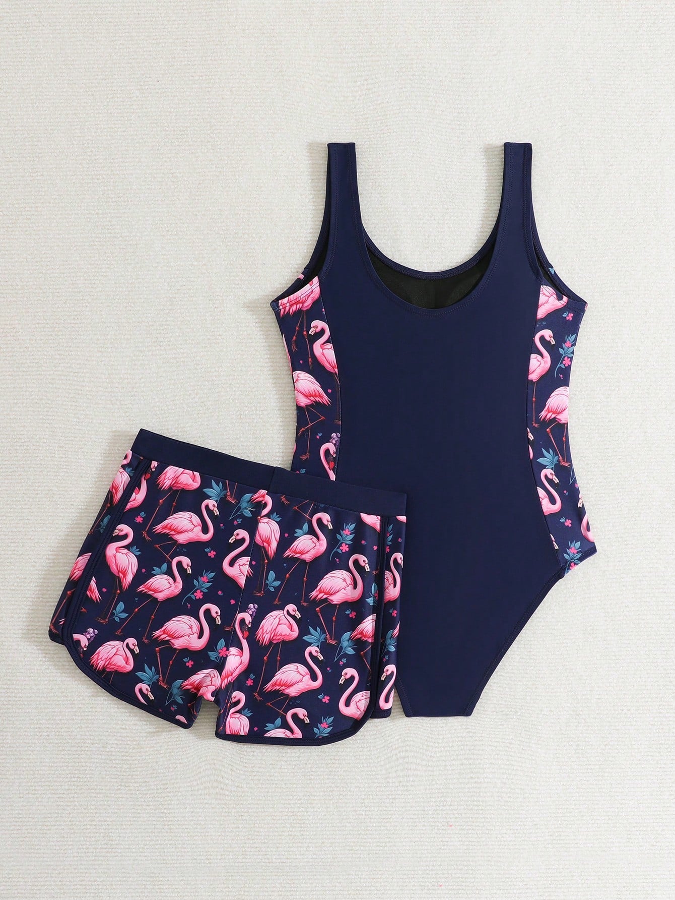 Tween girls 2-piece swimsuit set with a printed one-piece featuring ruffle trim, scoop neckline, cut-out detail, and matching shorts bottom.