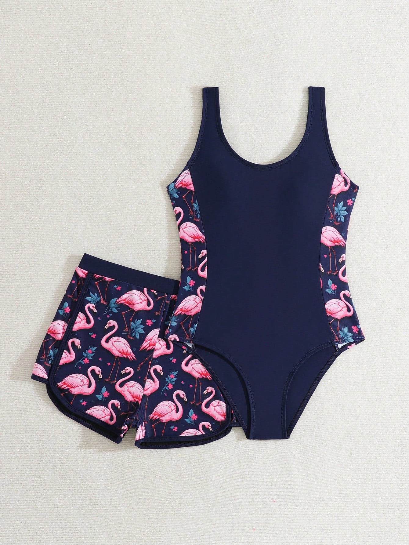 Tween girls 2-piece swimsuit set with a printed one-piece featuring ruffle trim, scoop neckline, cut-out detail, and matching shorts bottom.