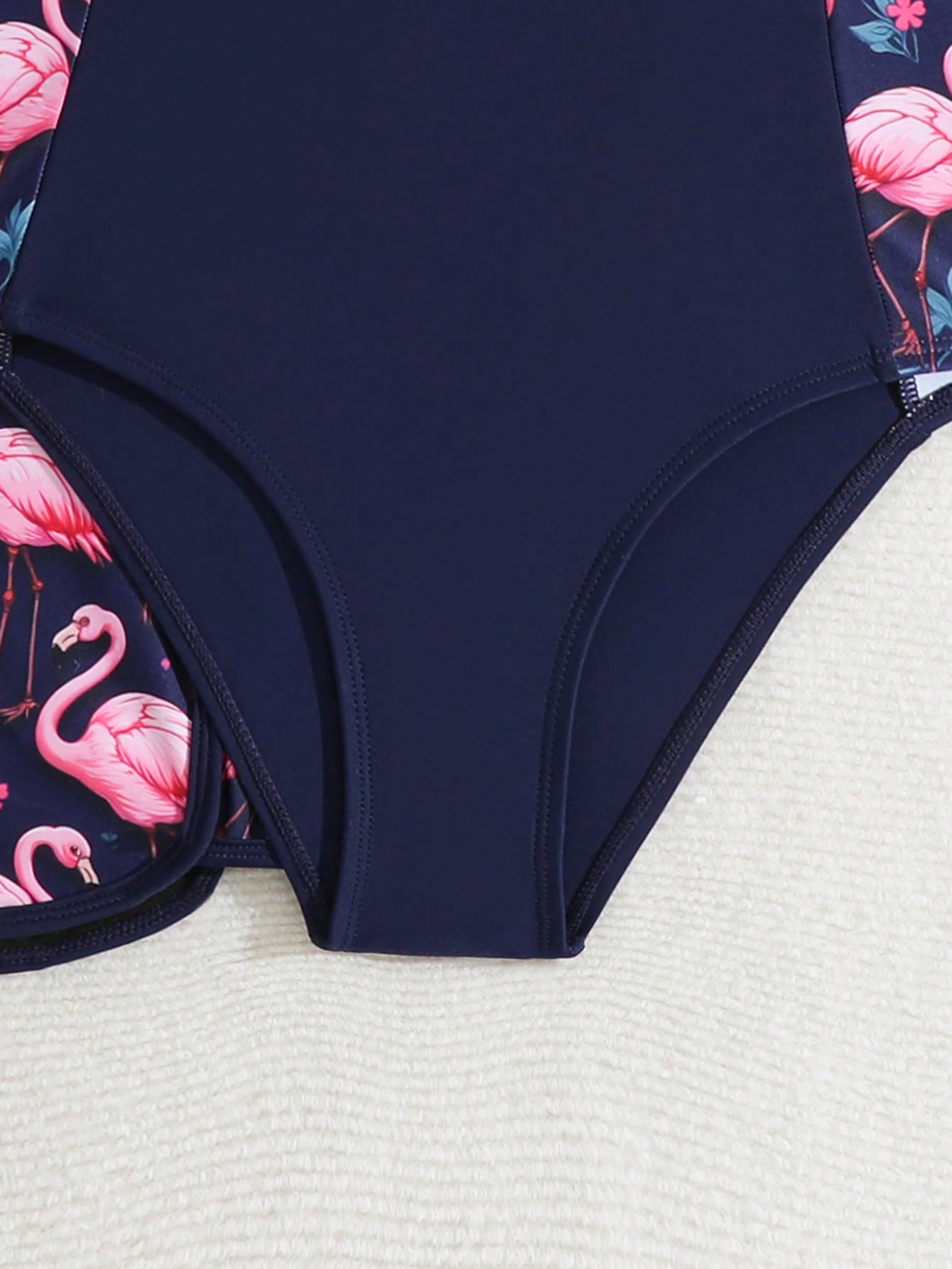 Tween girls 2-piece swimsuit set with a printed one-piece featuring ruffle trim, scoop neckline, cut-out detail, and matching shorts bottom.