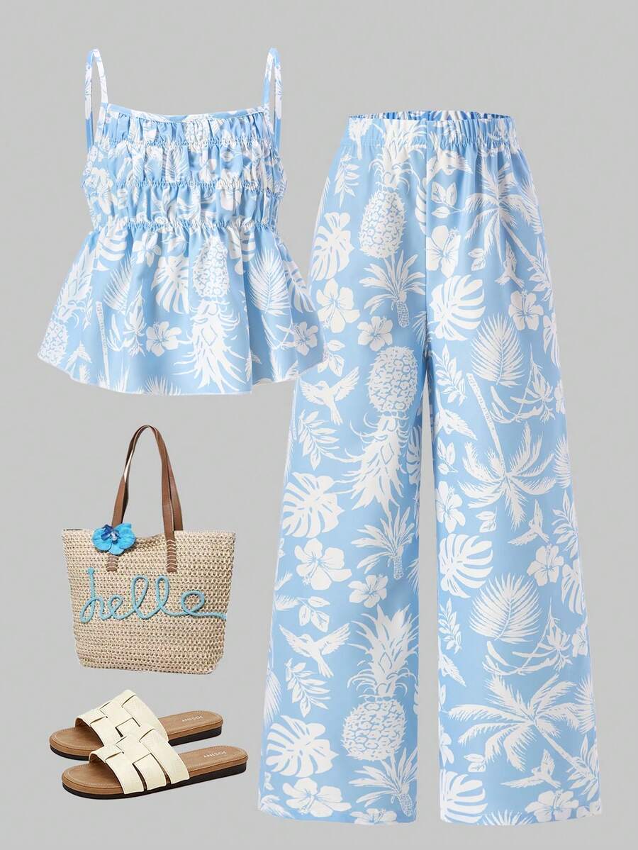 Tween girls light blue 2-piece summer vacation outfit featuring a plant print spaghetti strap camisole top with shirred ruffle hem and wide-leg long pants.