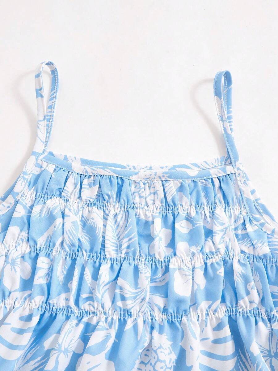 Tween girls light blue 2-piece summer vacation outfit featuring a plant print spaghetti strap camisole top with shirred ruffle hem and wide-leg long pants.