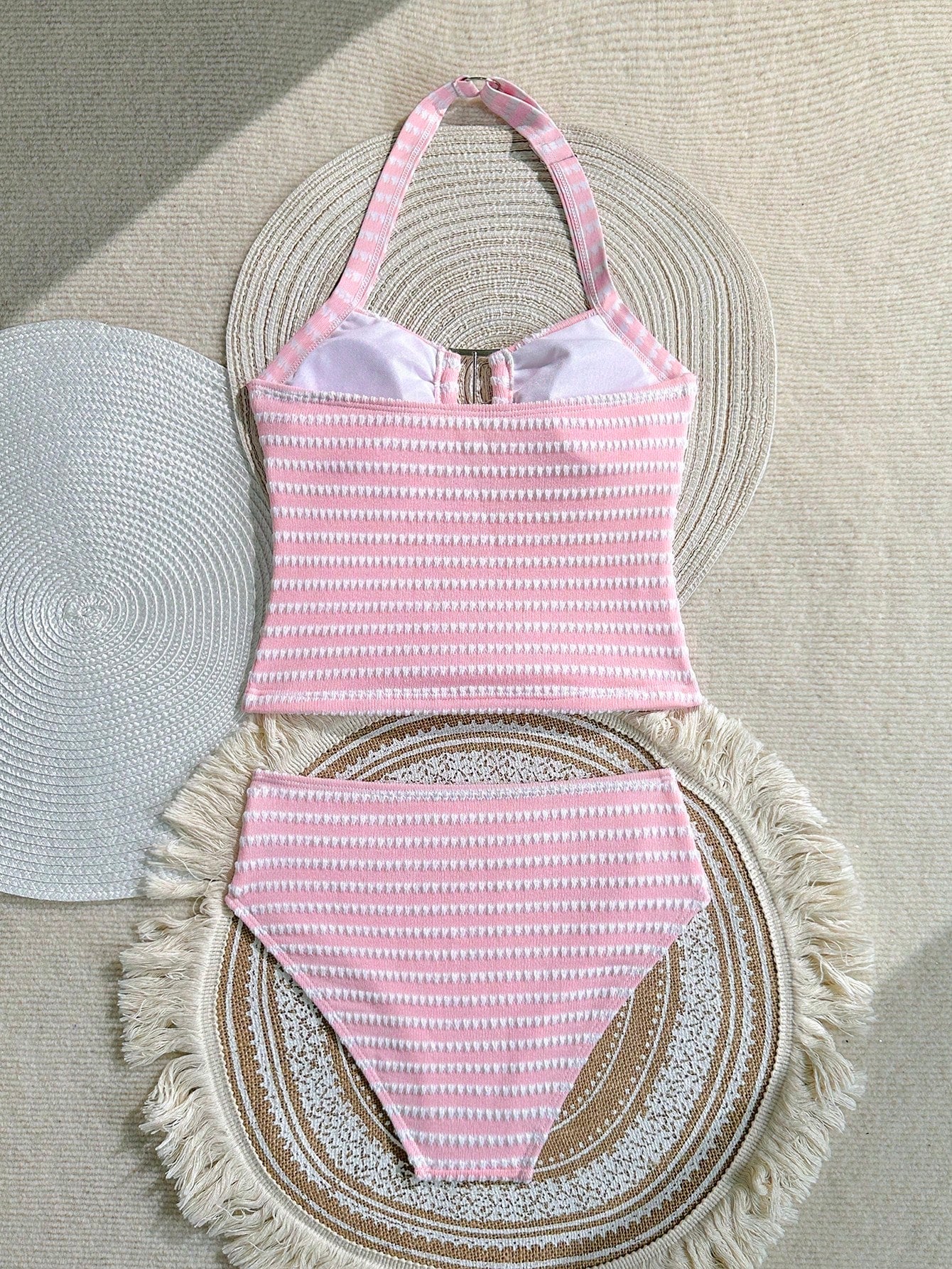Two-piece tween girls swimwear set in pink with a wavy striped pattern and metallic decor, featuring a halter sleeveless top and mid-waist bottoms in soft, medium-stretch knit fabric, suitable for beach or pool wear.