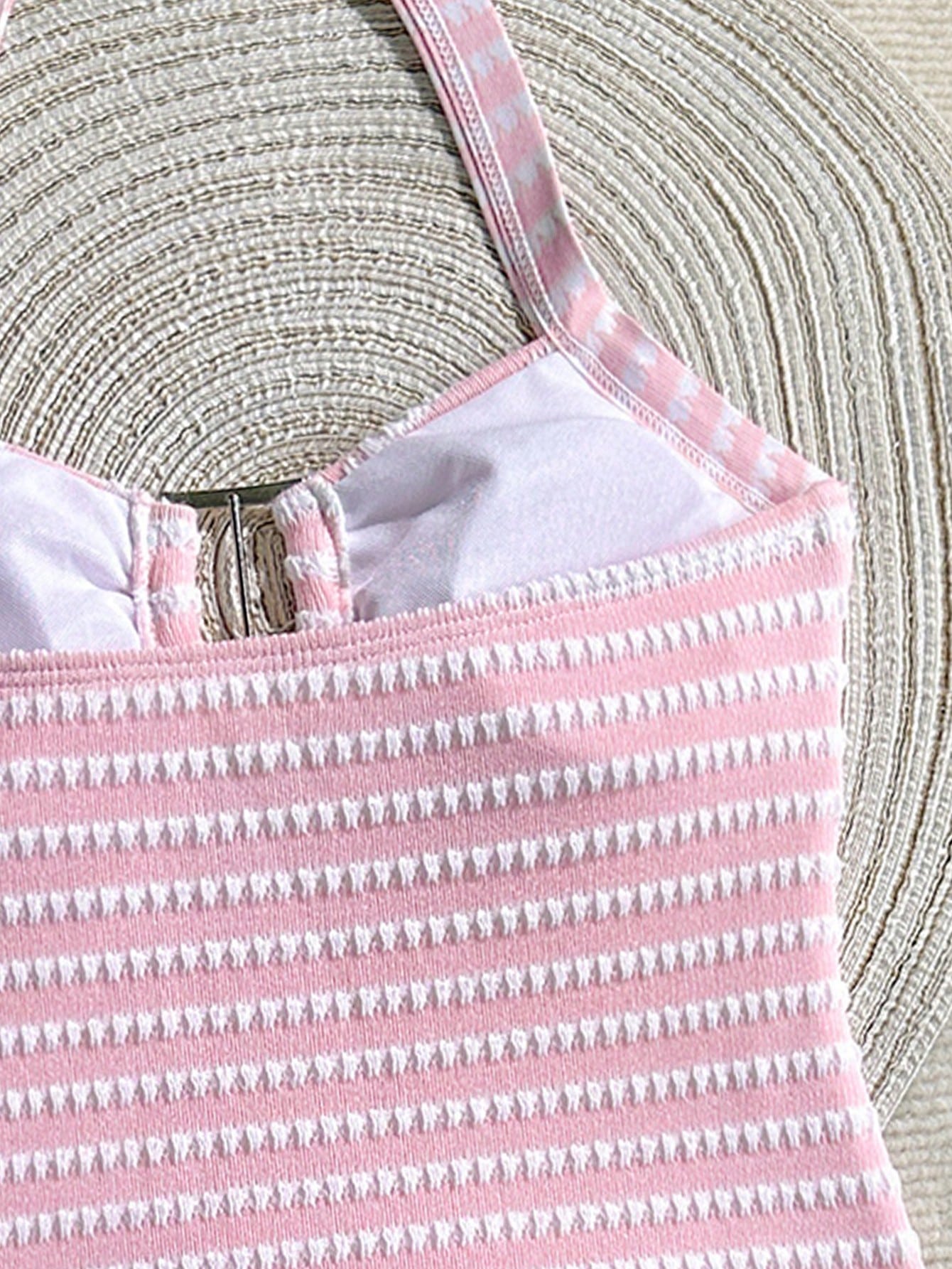 Two-piece tween girls swimwear set in pink with a wavy striped pattern and metallic decor, featuring a halter sleeveless top and mid-waist bottoms in soft, medium-stretch knit fabric, suitable for beach or pool wear.