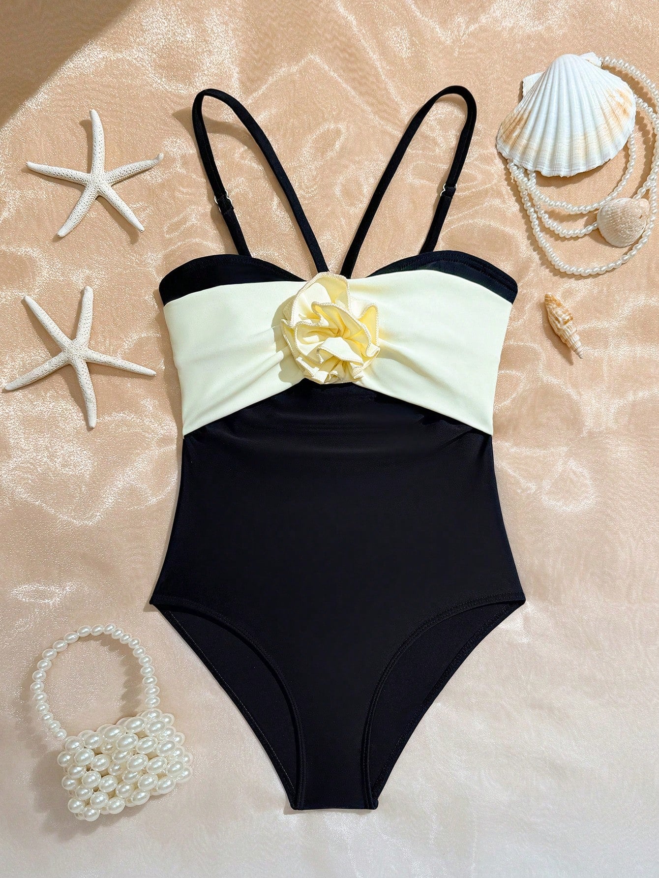 Tween girls one-piece swimsuit with a floral plant print, spaghetti straps, and a mid-waist fit in black.