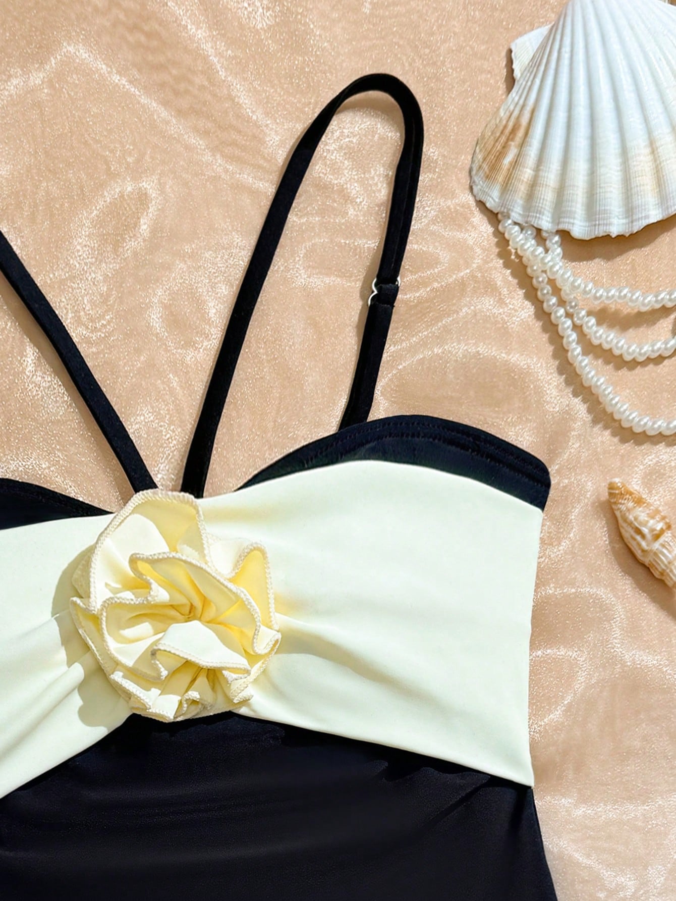 Tween girls one-piece swimsuit with a floral plant print, spaghetti straps, and a mid-waist fit in black.