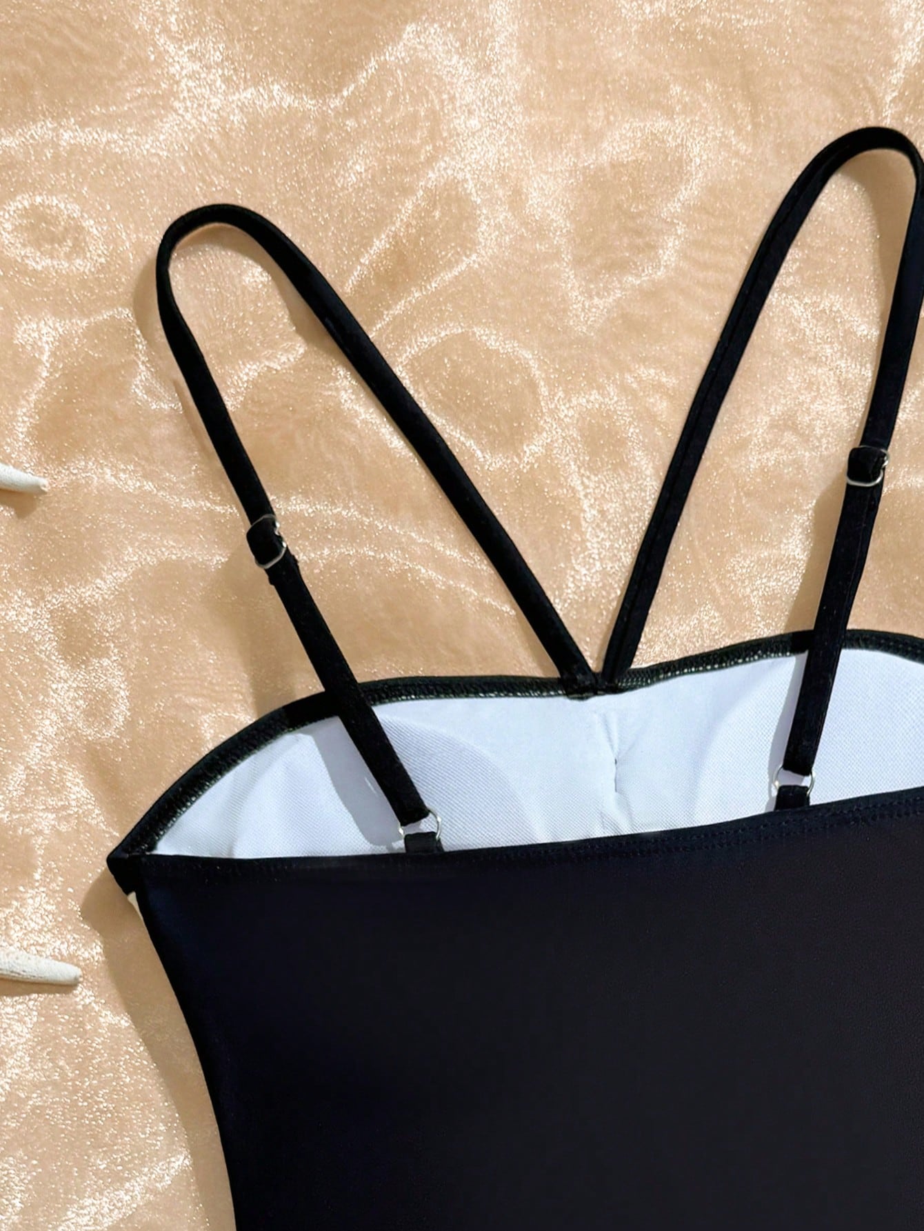 Tween girls one-piece swimsuit with a floral plant print, spaghetti straps, and a mid-waist fit in black.