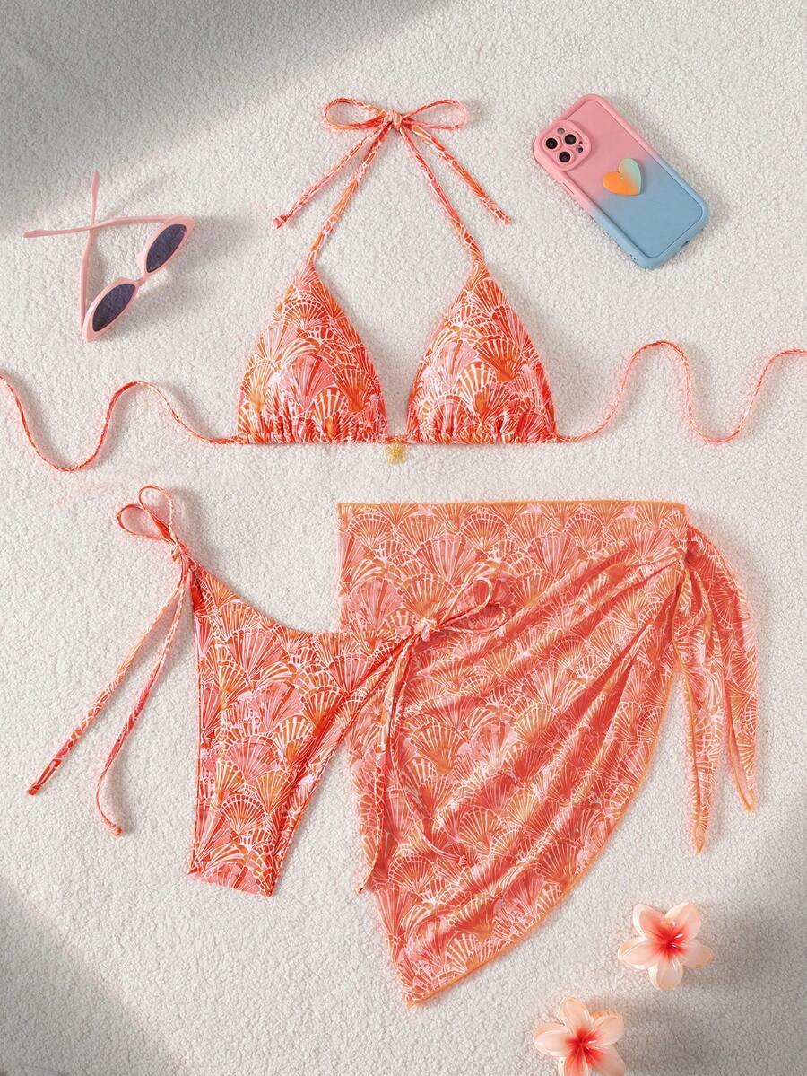 Women's 3-piece blue tropical shell print bikini set featuring a halter bralette top, low-waist tie-side bottom, and a matching sheer mesh cover-up skirt.